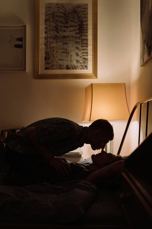 Two people sharing a quiet, intimate moment in a softly lit bedroom, symbolizing love, loss, and connection — bereavement psychotherapy support in Toronto.